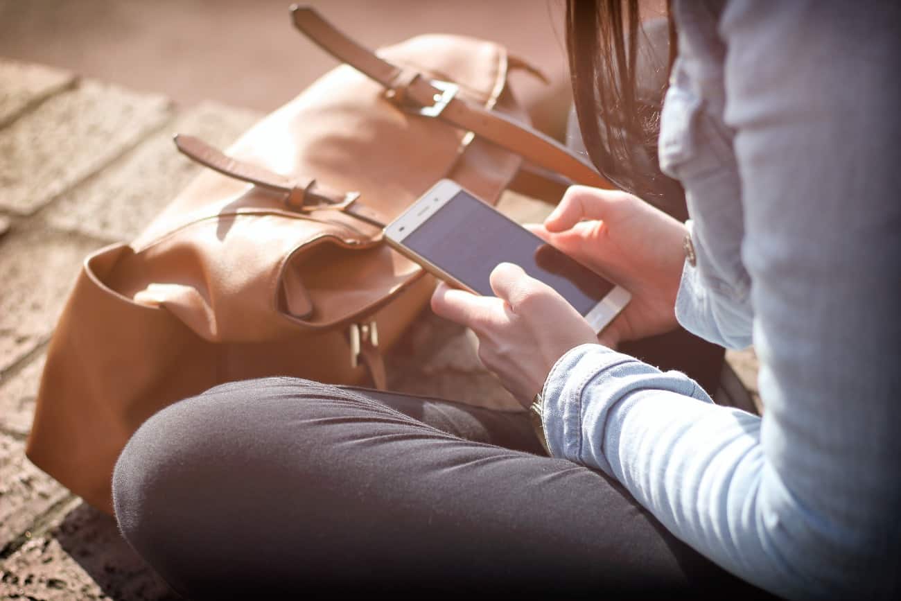 woman sitting down and staring at their phone