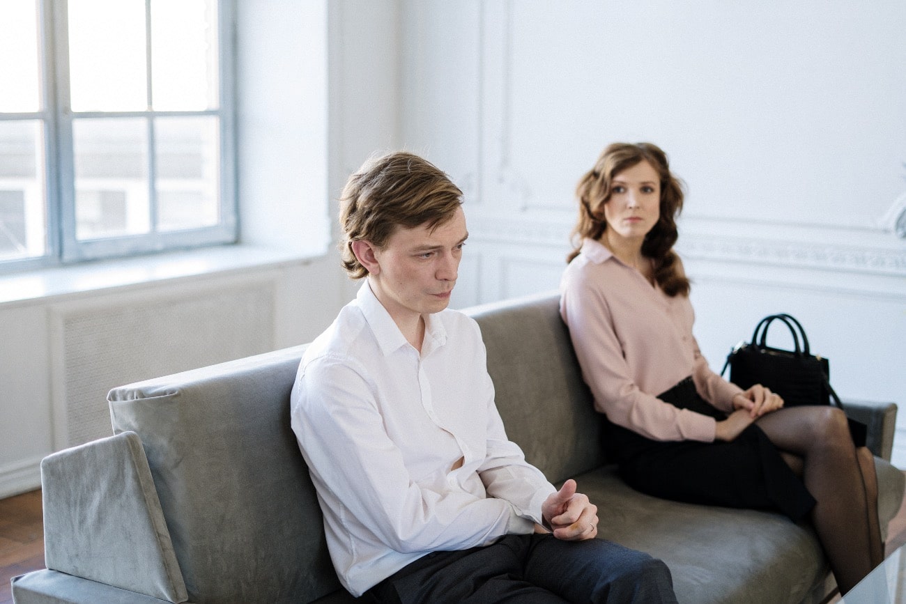 man and woman sitting on couch during therapy
