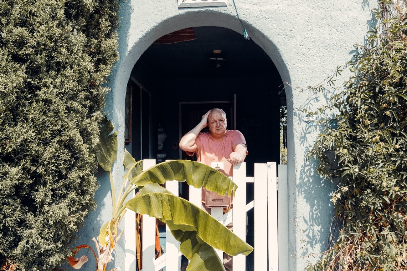 confused man standing outside of his house