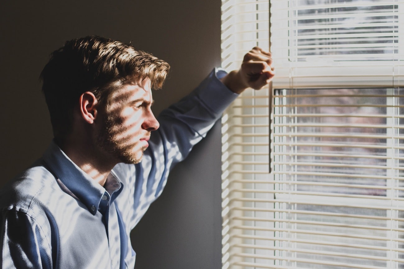 man staring out of window