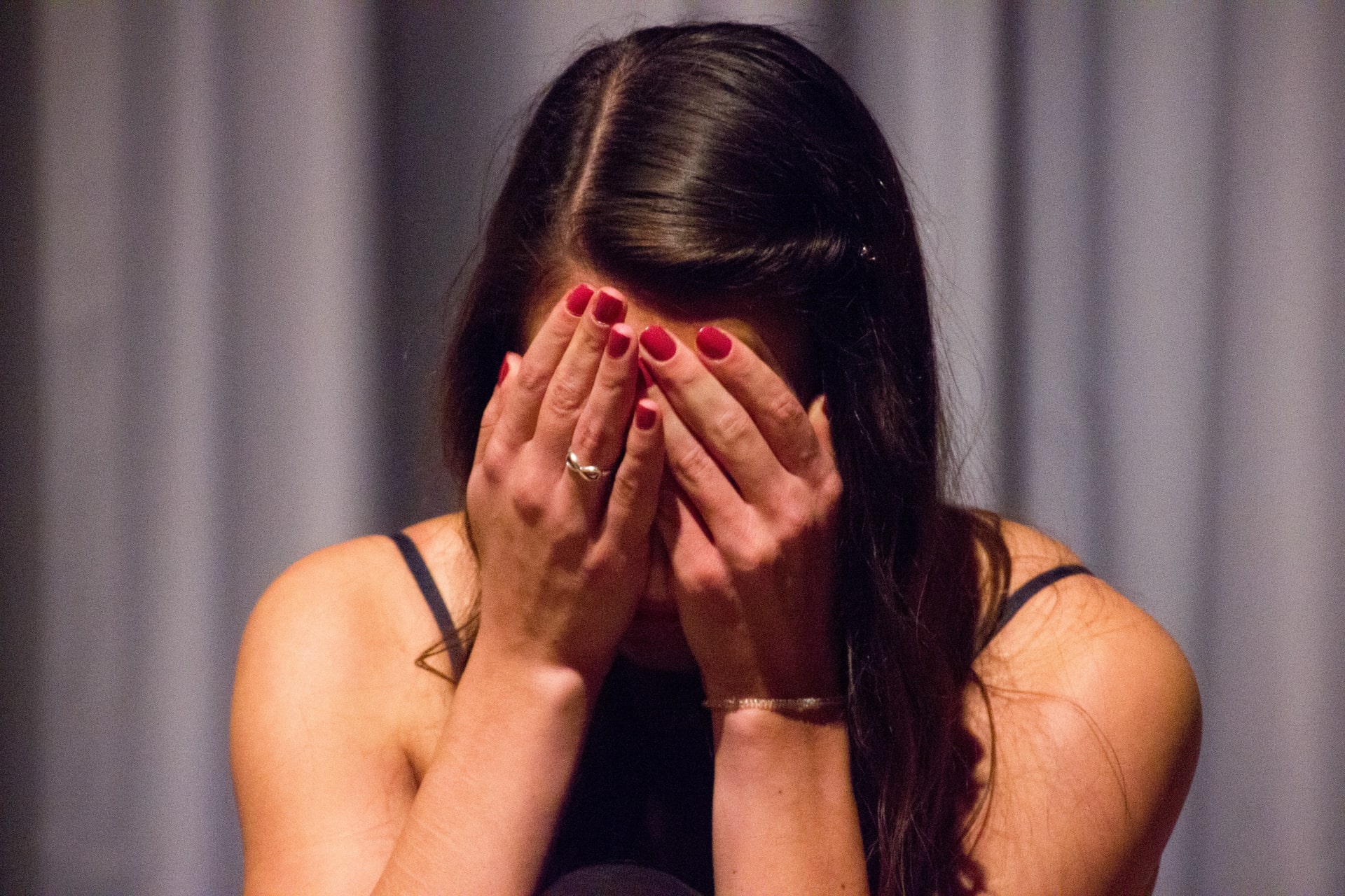 stressed woman with hands covering face