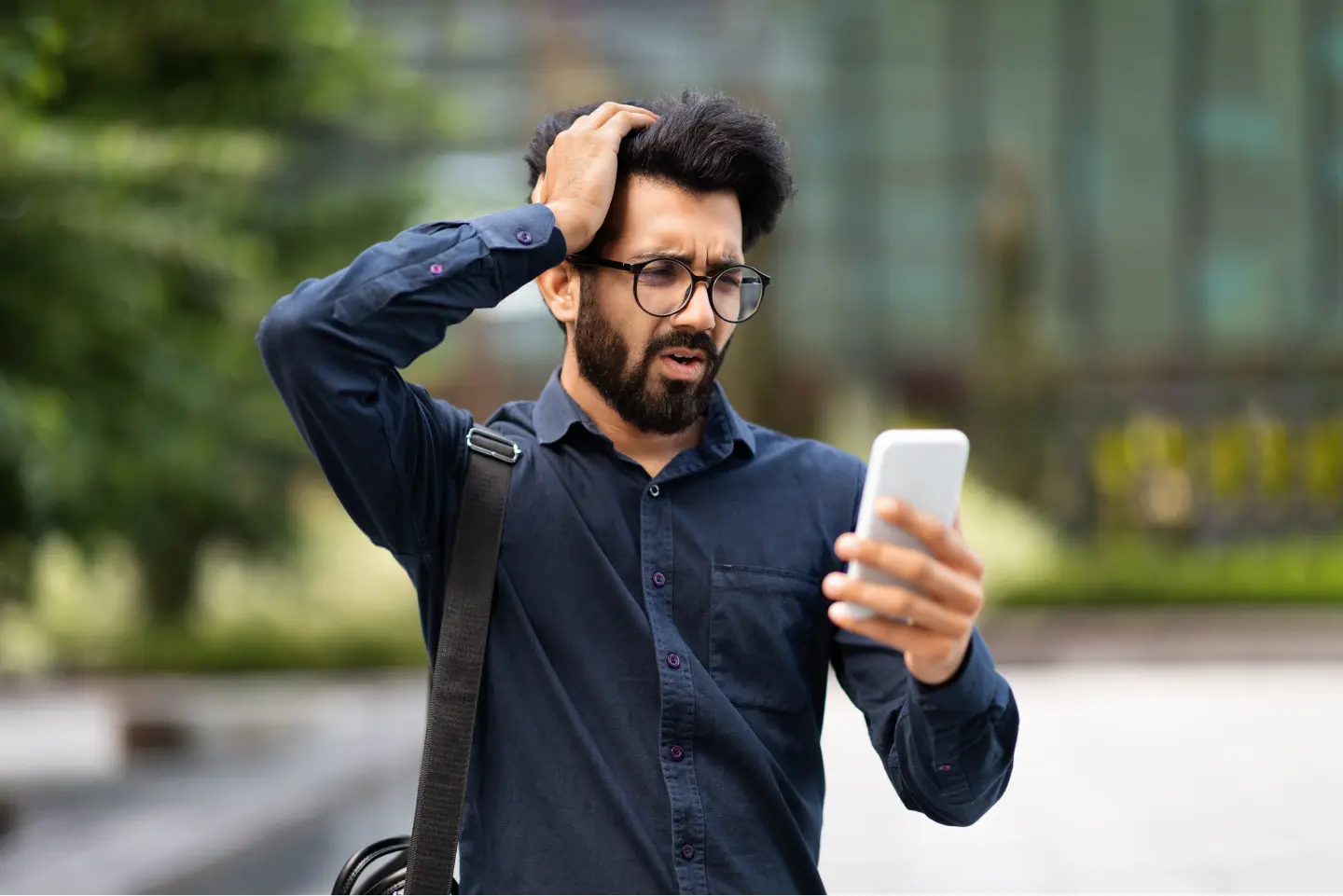 man looking at phone confused