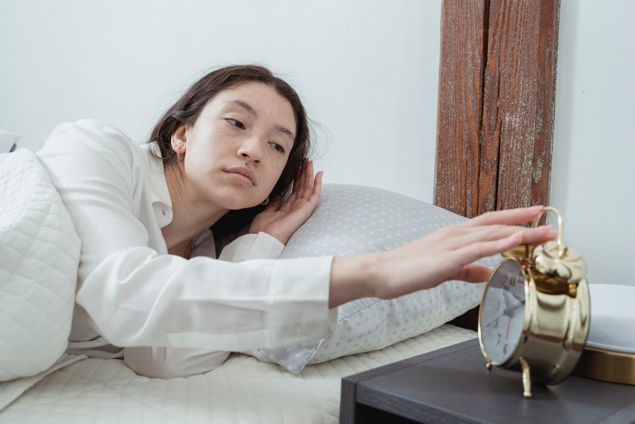 woman hitting her alarm clock